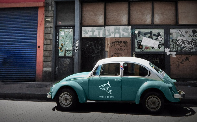 Picture of a VW bug with fix group logo on it.